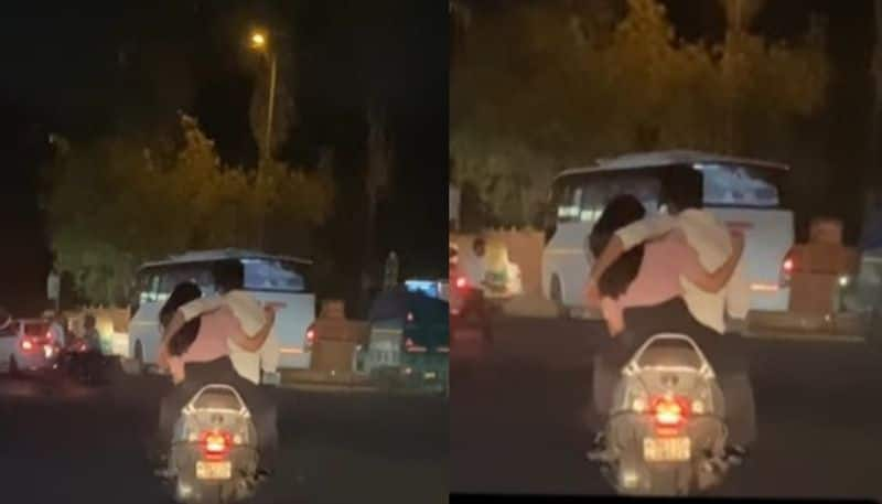 lovers hugs each other while riding scooter hyp 