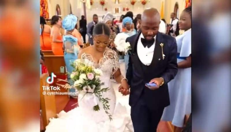 groom using phone while walking with bride inside church the video going viral hyp