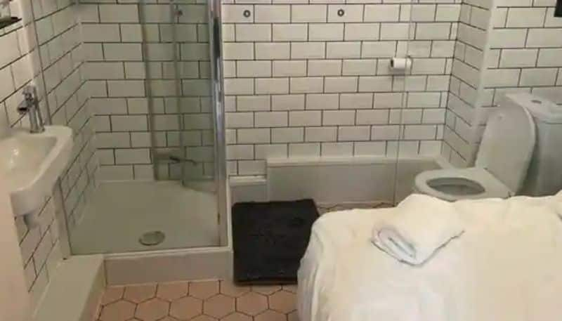 man shares picture of hotel room there bed and toilet are in same space hyp