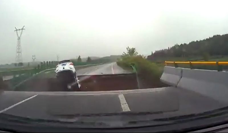 WATCH Terrifying video shows car plunging into massive crater in China as Typhoon Doksuri destroys roads snt