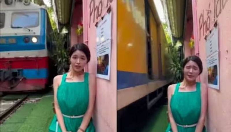 woman standing very near to moving train viral video from Hanoi Train Street rlp