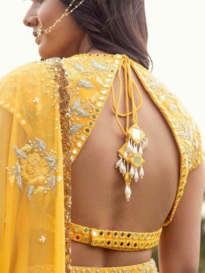 <p> नीच हुक ऊपर डोरी वाले  इस ब्लाउज़ में आप देसी लुक में ग्लैमर का तड़का लगाएंगी</p>
