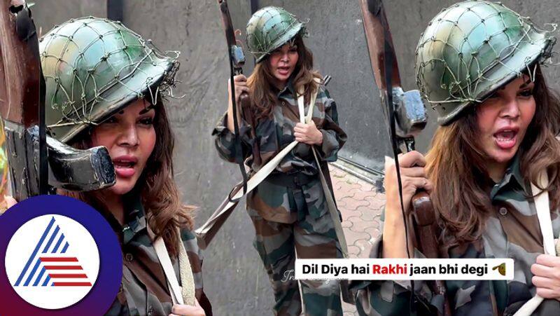 Actress Rakhi Sawant is wearing a soldiers uniform and holding a gun troll suc