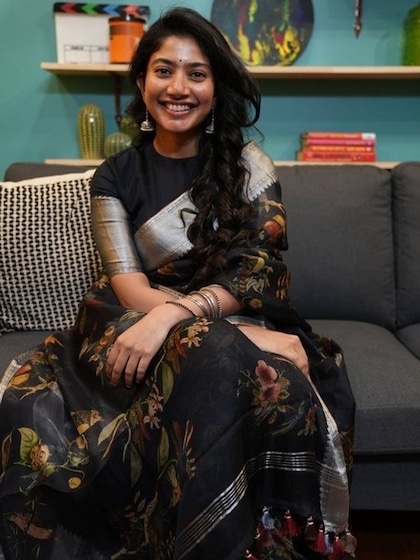 <p>ब्लैक शिफॉन प्रिंटेड साड़ी पर साईं पल्लवी ने ऑक्सिडाइज इयररिंग पहनी है नो मेकअप के साथ माथे पर काली बिंदी है जिसमें वह सुंदर लग रही है। ऑफिस  फंक्शन के लिए यह साड़ी बेहतरीन रहेगी।</p>
