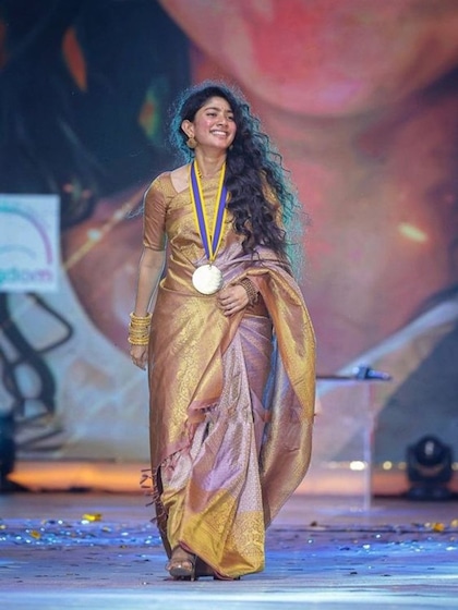 <p>बनारसी साड़ी का फैशन कभी नहीं जाता है यह साड़ी एवरग्रीन होती है साईं पल्लवी ने पर्पल और गोल्डन कलर की बनारसी साड़ी पहनी है जिसे उन्होंने मैचिंग ज्वैलरी के साथ पेयर किया है। </p>
