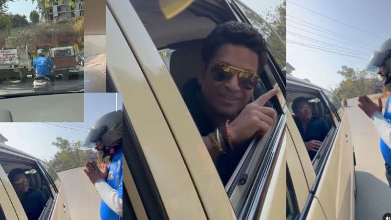 The cricket god sachin tendulkar speaks with his big fan riding a scooter wearing a t-shirt with Sachins name akb