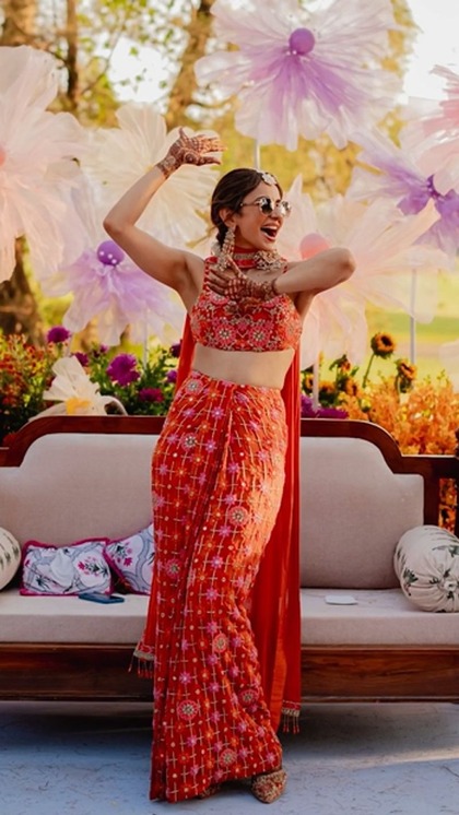 <p>रकुल ने मेहंदी फंक्शन के लिए डिफरेंट कलर चुना। उन्होंने ग्रीन-येलो से हटकर अर्पिता मेहता का डिजाइन किया हुआ ऑरेंज पिंक लहंगा पहना था। लहंगे को को आर्ड सेट जैसा तैयार किया गया था। </p>
