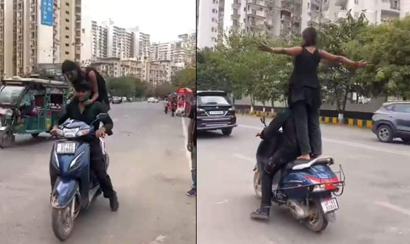 Women stunt on moving scooter with titanic pose during holi festival Noida police issues rs 33000 fine ckm 