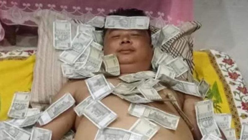 A photo of an Assam politician sleeping on a pile of rupee notes has gone viral smp