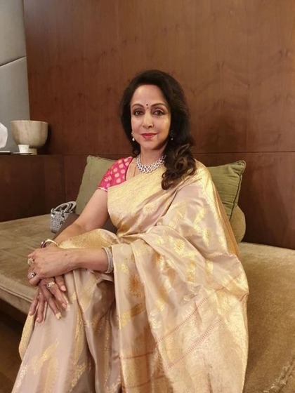 <p>हेमा मालिनी ने गोल्डन कलर की बनारसी साड़ी पहनी है जिसके साथ उन्होंने फ्यूशिया कलर का कंट्रास्ट ब्लाउज लगाया है। गले में स्टोन की ज्वेलरी से अपने लुक को कंप्लीट किया है।</p>
