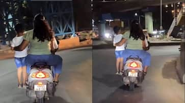 Bengaluru couple rides scooter with child standing footrest, Internet puzzled; WATCH viral videortm