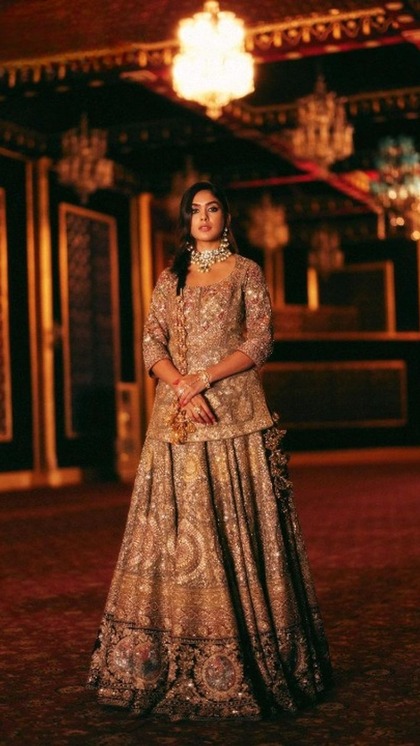 <p>आजकल हैवी एंब्रॉयडरी लहंगा के साथ शर्ट ब्लाउज पहनने का चलन है। आप भी मृणाल ठाकुर के गोल्डन आउटफिट से इंस्पिरेशन ले सकती हैं। उन्होने हैवी नेकलेस पहना है जो गॉर्जियस लग रहा है।</p>
