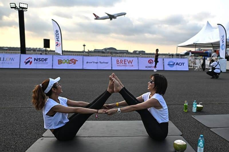 Yogis take flight! Hundreds of people perform yoga on runway of Bangkok's main airport (WATCH) snt