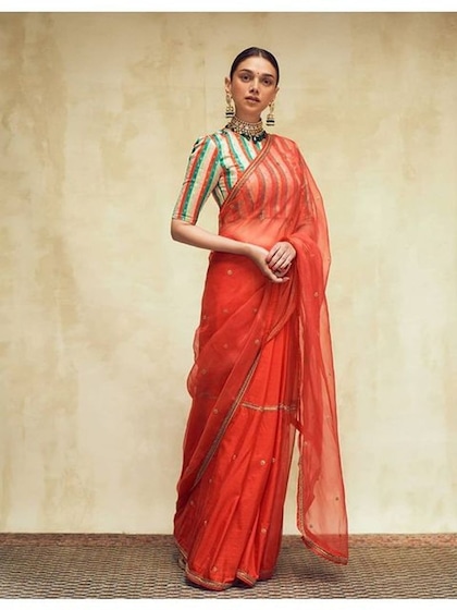 <p>अदिति ने नेट ऑरेंज साड़ी के साथ स्ट्राइप ब्लाउज पहना है। न्यूड मेकअप और कोरल ज्वेलरी से टीम अप किया है जिसमें वह बहुत ग्रेसफुल लग रही है।</p>
