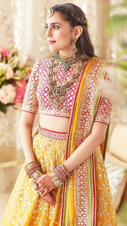 <p>श्लोका मेहता ने येलो लहंगे के साथ रेड राउंड नेक ब्रोकेड ब्लाउज कैरी किया है। आप भी ऐसा ब्लाउज टेलर से स्टिच करा सकती हैं। ये प्लेन साड़ी-लहंगे को हैवी लुक देने के लिए बेस्ट है।</p>
