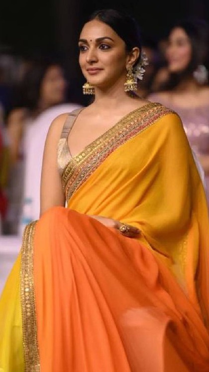 <p>कियारा आडवाडी ने ऑरेंज और येलो के दो शेड्स वाली साड़ी पहनी है। प्लेन साड़ी के बॉर्डर में मिरर वर्क साड़ी के लुक को इनहेंस कर रहा है। गर्मियों की पार्टी में ये लुक लाजवाब है। </p>
