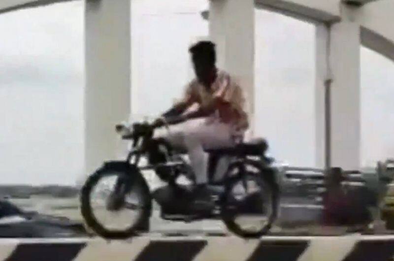 Young man rides bikes on narrow divider in Tamil Nadu Dangerous stunt goes viral ckm