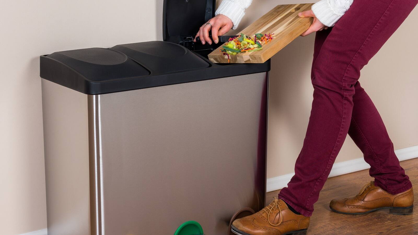 woman throwing wasted food into steel bin