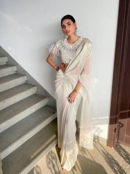 <p>आथिया ने यहां रेडी टू वेयर व्हाइट साड़ी पहनी है जिसके साथ उन्होंने हेवी एंब्रायडर्ड ब्लाउज पहना है। रोजी मेकअप हैवी इयररिंग और बालों का जूड़ा बना कर लुक कंप्लीट किया है।</p>
