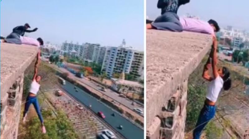 a young woman hanging from the edge of a building holding a boy's hand for Instagram reels Netizens outraged by the horrifying stunt akb