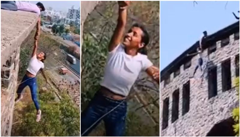 teen girl hangs from edge of a building to film reel viral video