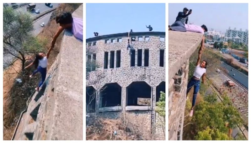 video of a teenager hanging from the top of a building with one hand has gone viral