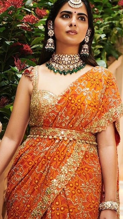 <p>अंबानी खानदान की इकलौती बेटी ईशा अंबानी ने ऑरेंज गुजराती साड़ी को डायमंड नेकलेस के साथ टीमअप किया। जिसमें नीचे ग्रीन स्टोन लगे हैं। साथ में हैवी झुमके,मांगटीका भी प्यारा लग रहा है। </p>
