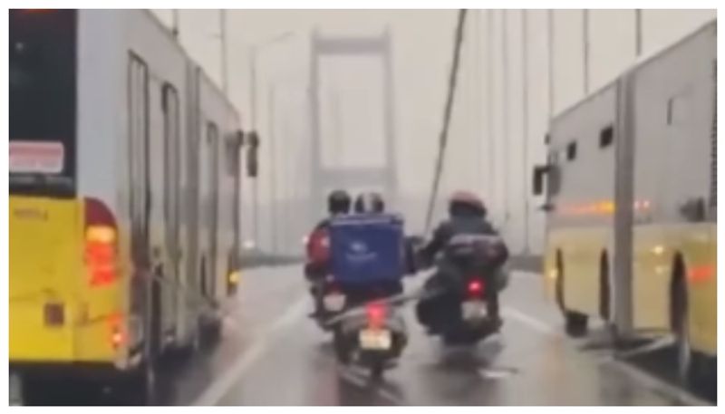 video of two buses helping a delivery boy cross the bridge from a raging storm has gone viral