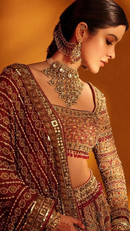 <p>शनाया के हैवी लहंगा लुक में स्क्वायर नेकलाइन ब्लाउज बेहद खूबसूरत लग रहा था। ब्लाउज के नीचे लाल रंग की मोती की लटकन और फुल स्लीव्स शनाया को रॉयल लुक दे रही हैं। </p>
