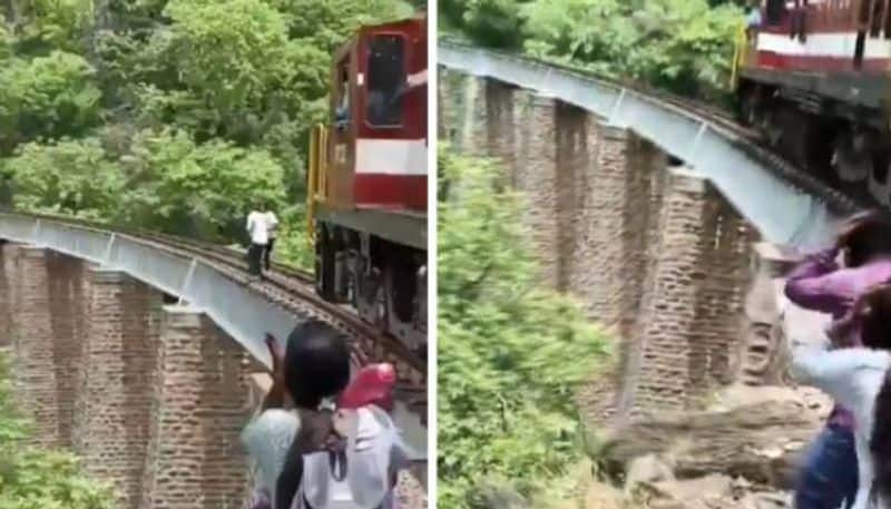 photo shoot in track  train arrives couple jumps into 90 ft gorge 