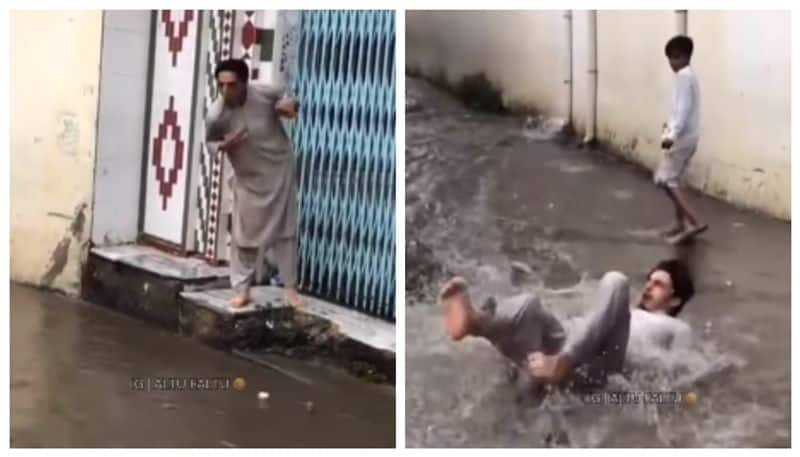 Video of a young man trying to jump over a waterlogged road but falling on the road has gone viral