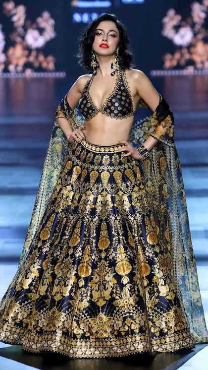 <p>दिव्या खोसला ने गोल्डन और ब्लैक कलर के कॉन्बिनेशन का बेहद खूबसूरत हैवी लहंगा वियर किया है। लुक को डीसेंट बनाने के लिए ब्रालेट स्टाइल ब्लाउज पहना है।</p>
