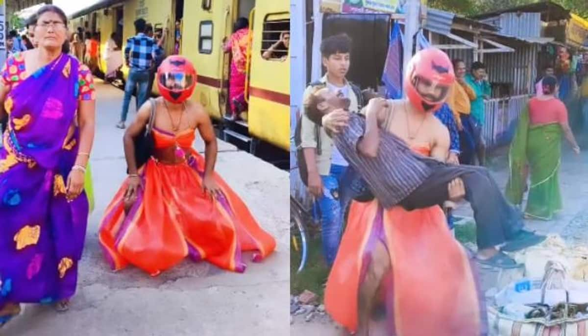 man wearing lehenga and helmet dancing at railway station 