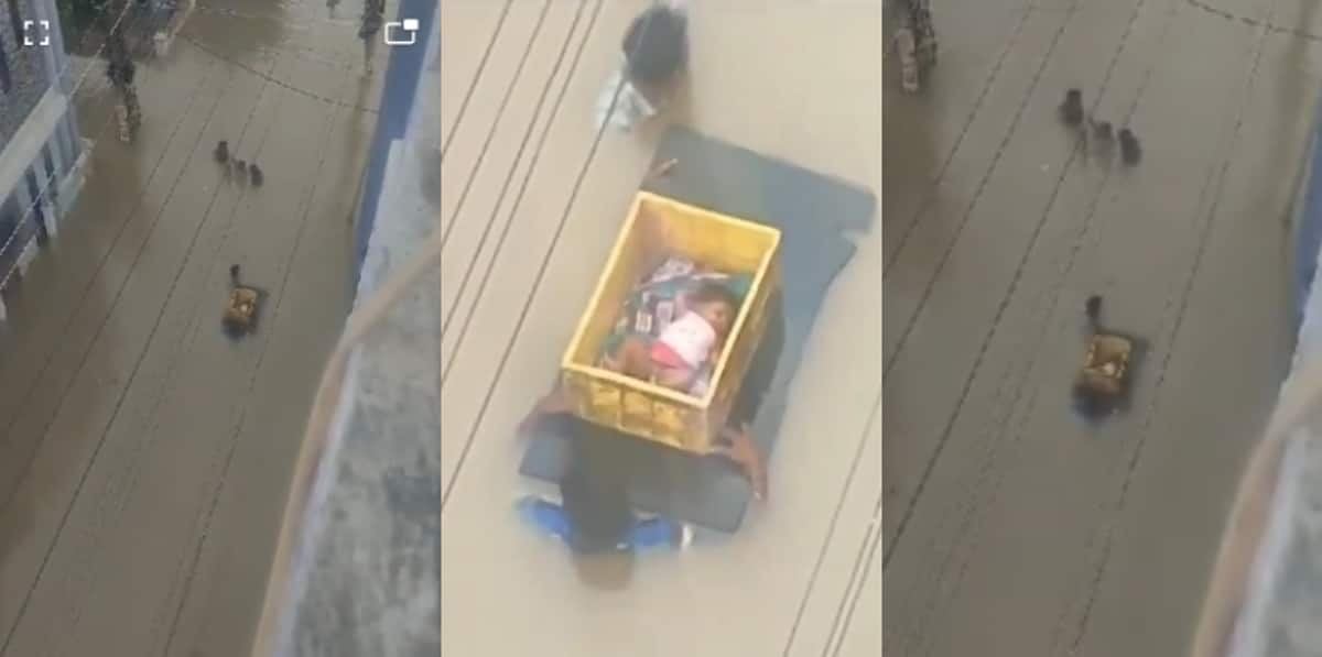 Baby In Plastic Crate Carried By Men In Neck Deep Waters in Vijaywada High-Angle Shot