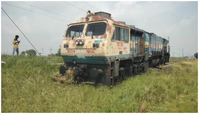 people amazed to see a locomotive in the field after derailing while running through loop line