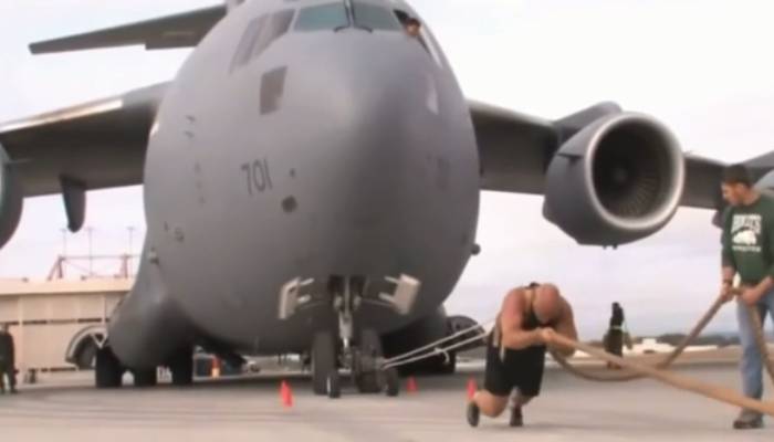 man pulls 189 ton massive flight with a rope in his waist 