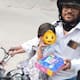 Swiggy delivery agent works with his two year old daughter sat