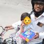 Swiggy delivery agent works with his two year old daughter sat