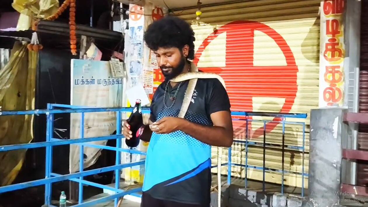 பாம்பை கழுத்தில் போட்டு கொண்டு டாஸ்மாக் கடைக்கு வந்த இளைஞர்! அலறி ஓடிய குடிமகன்கள்!