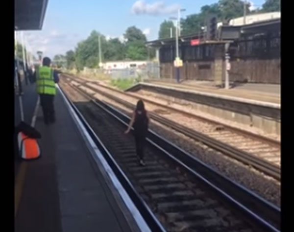 Shocking moment woman is spotted walking on Woking train tracks