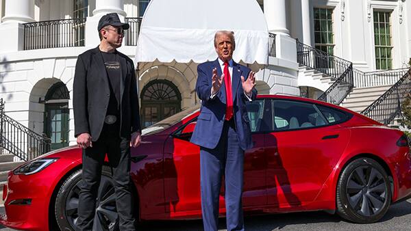 US President Donald Trump and Tesla CEO Elon Musk with a Tesla car in the background (Image Credit: Reuters)